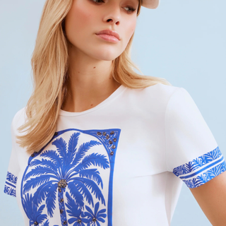 Woman in White T with Blue Palm tree print  on pale background 