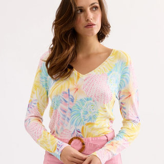 Woman wearing a colorful tie-dye long-sleeve shirt with a plain background