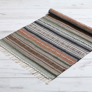 Woven rug with striped pattern on a light wooden floor
