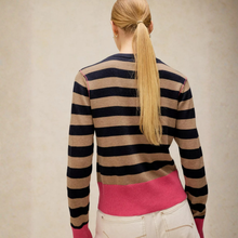 Load image into Gallery viewer, A woman viewed from behind wearing a long-sleeve knit sweater with horizontal stripes in beige, navy, and bright pink, paired with off-white pants.
