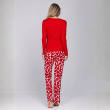 Load image into Gallery viewer, A woman viewed from behind wearing a red long-sleeve top and red-and-white heart-patterned pants against a light gray studio background.

