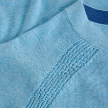 Load image into Gallery viewer, Close-up of a light blue knit crewneck sweater showing the fine knit texture and a darker blue inner collar lining.
