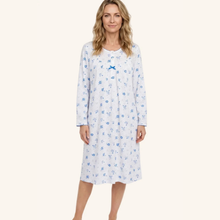 Load image into Gallery viewer, A woman modeling a long-sleeve nightgown with a blue floral pattern on a white background, featuring a small bow at the chest, set against a solid light beige backdrop.
