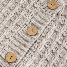 Load image into Gallery viewer, Close-up of a knitted fabric with a herringbone pattern and wooden buttons.

