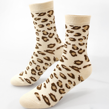 Load image into Gallery viewer, A pair of crew socks with a leopard print pattern in brown and tan on a cream background, displayed against a plain white background.
