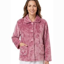 Load image into Gallery viewer, A woman wearing a dusty pink fleece pajama jacket with a subtle damask pattern, button-front closure, and front pockets, shown against a plain white background.
