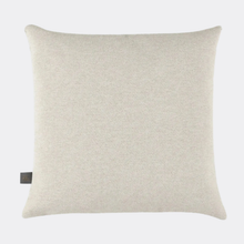 Load image into Gallery viewer, A square throw pillow in a textured cream or off-white fabric, shown against a light gray background. A small dark brown brand tag is stitched on the bottom-left corner.

