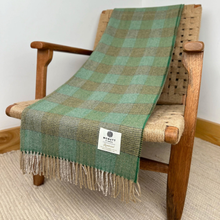 Load image into Gallery viewer, Green checkered blanket draped over a wooden chair with a visible brand label.
