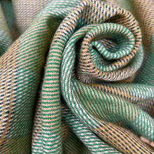 Load image into Gallery viewer, Close-up of a rolled-up green and beige fabric with a textured pattern.
