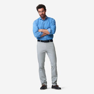Man wearing a blue shirt and gray pants on a white background
