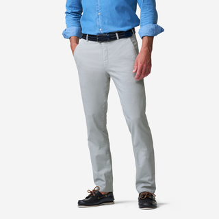 Person wearing light gray pants with a blue shirt on a white background