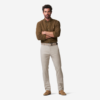 Man wearing a brown shirt and beige pants on a white background