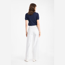 Load image into Gallery viewer, Woman wearing a navy blue top and white pants on a white background
