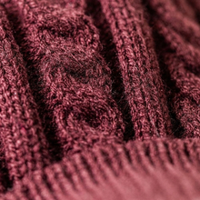 Load image into Gallery viewer, Close-up of a textured knit fabric in a deep burgundy or maroon shade, showing ribbed and cable-knit patterns.
