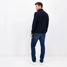 Load image into Gallery viewer, Photo of a model with his back to the camera wearing the navy polo neck from Fynch Hatton, blue jeans and white shoes
