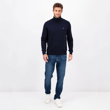 Load image into Gallery viewer, Photo of a Model looking at the camera wearing the Navy Polo Neck from Fynch Hatton wearing blue jeans and white shoes
