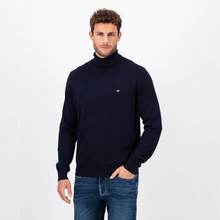 Load image into Gallery viewer, Photo of a Model looking at the camera wearing the Navy Polo Neck from Fynch Hatton with his left hand in his jeans pocket
