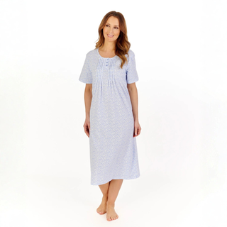 Woman wearing a light blue patterned nightgown on a white background