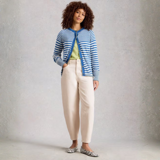 Full view of model wearing White Stuff Aubrey Barrel Leg Jean in white, with a light grey background.