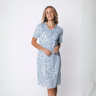 Woman wearing a light blue floral dress against a white background