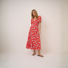 Load image into Gallery viewer, Woman wearing a red floral dress against a plain background
