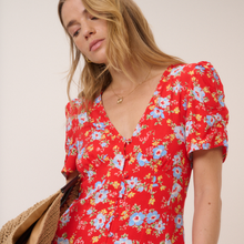 Load image into Gallery viewer, Woman wearing a red floral dress against a plain background
