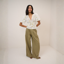 Load image into Gallery viewer, Woman wearing a floral blouse and wide-leg pants against a plain background
