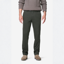 Load image into Gallery viewer, A man wearing dark olive green slim-fit trousers, a ribbed taupe knit sweater, and brown suede mules, shown from the chest down against a plain white studio background.
