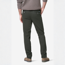 Load image into Gallery viewer, A man wearing dark olive green chinos, a gray ribbed sweater, and brown suede boots, shown from a rear three-quarter angle against a white studio background.
