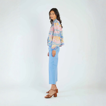 Load image into Gallery viewer, Woman wearing a colorful plaid shirt and light blue jeans on a white background
