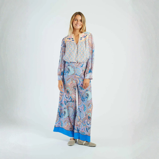 Woman wearing a patterned outfit on a white background