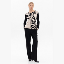 Load image into Gallery viewer, Woman wearing a black and white patterned top with black pants on a white background
