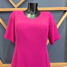 Load image into Gallery viewer, Pink dress on a mannequin against a geometric-patterned wall.

