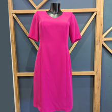 Load image into Gallery viewer, Pink dress on a mannequin against a geometric wooden frame and blue wall background
