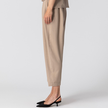 Load image into Gallery viewer, Beige pants worn by a person on a white background
