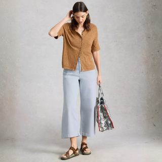 Model posing, wearing White Stuff Tia Wide Leg Crop Jean, with a  light grey background.