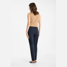 Load image into Gallery viewer, A woman is shown from the back wearing navy blue trousers, a beige sleeveless knit top, and black pointed-toe heels against a plain white studio background.
