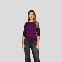 Load image into Gallery viewer, Woman wearing a purple sweater and black jeans on a light gray background
