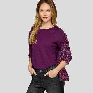 Woman wearing a purple top with colorful sleeves on a gray background