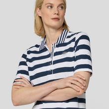 Load image into Gallery viewer, Woman wearing a navy and white striped polo shirt on a light gray background
