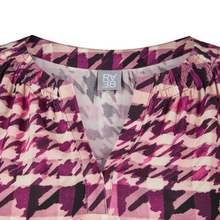 Load image into Gallery viewer, Close-up of a patterned garment with a brand label on a white background
