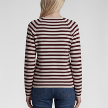 Load image into Gallery viewer, A woman viewed from the back wearing a long-sleeve knit sweater with horizontal burgundy and cream stripes, paired with blue jeans, against a light gray studio background.
