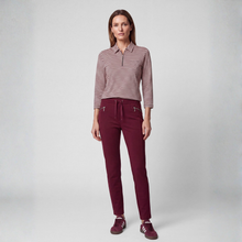 Load image into Gallery viewer, A woman stands against a light gray studio background wearing a long-sleeve collared knit top with thin horizontal burgundy and beige stripes, paired with burgundy drawstring pants and matching burgundy sneakers.
