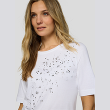 Load image into Gallery viewer, Woman wearing a white t-shirt with black speckles against a plain background
