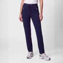 Load image into Gallery viewer, A model wearing navy blue drawstring sweatpants with zippered pockets, paired with a white top and gray sneakers, shown from the waist down against a light gray studio background.
