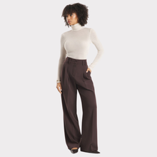 Load image into Gallery viewer, Woman wearing a white turtleneck and brown wide-leg pants on a light gray background
