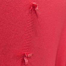 Load image into Gallery viewer, Close up of Kate &amp; Pippa Coral Jumper With Bows on Back, in Red.
