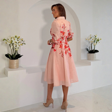 Load image into Gallery viewer, Woman in a pink floral dress standing in a minimalistic room with white walls and a white floor.
