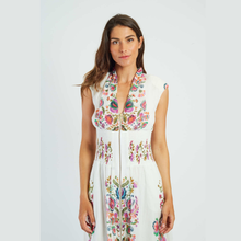 Load image into Gallery viewer, Woman wearing a white dress with colorful floral embroidery on a plain background
