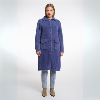 Woman wearing a long blue coat on a white background